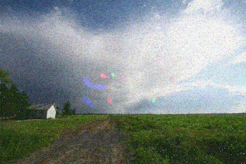 An animation showing visual snow symptoms against a backdrop of a green field and a blue sky.